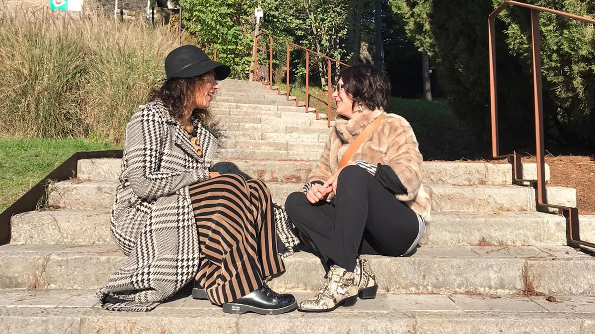 Silvia e Stefania sedute sui gradini mentre conversano all’aperto